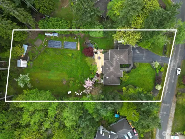 An aerial view of the light filled lot. Chicken coop, deer-proof fenced garden, 2 fire pits and a lovely pond. Don't miss the RV parking too! So much room to relax.