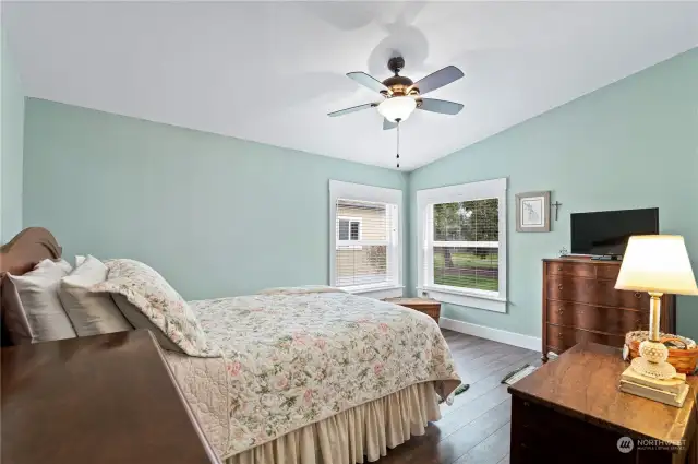 Primary suite with ceiling fan looks out to back yard.