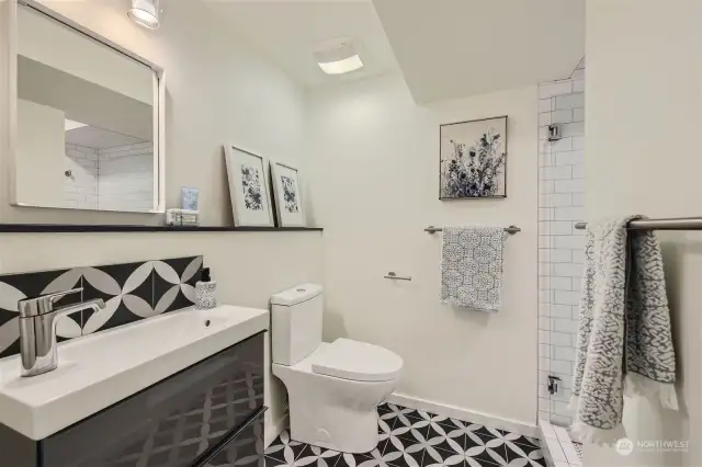 Lower level bathroom is updated with heated floors and a beautiful penny-tile shower.