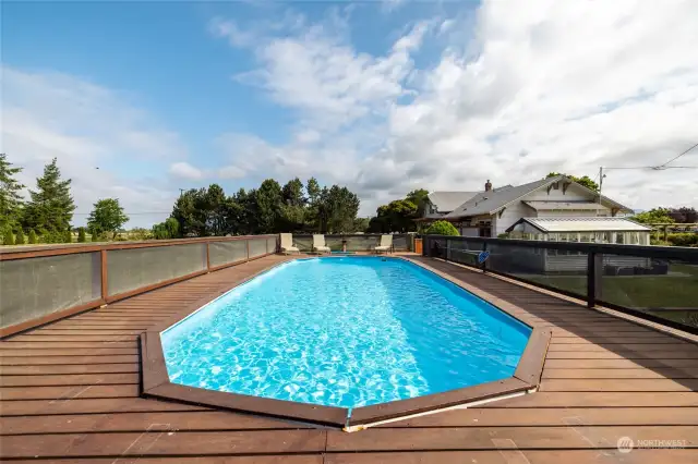 Above ground pool with surrounding deck.