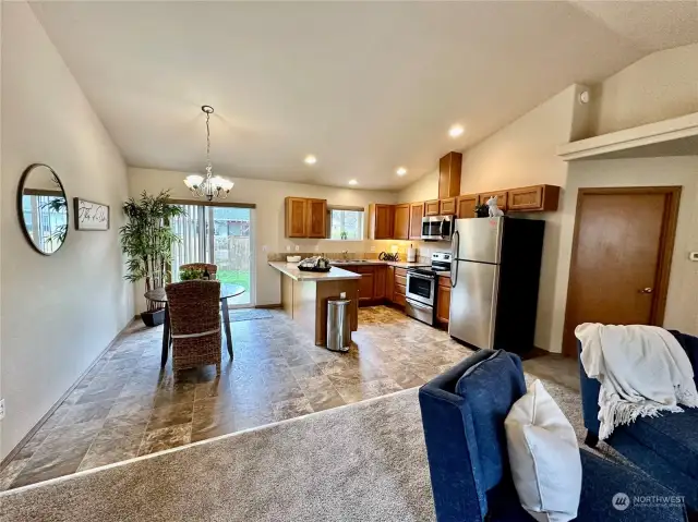 Open kitchen with adjoining dining area with access to the rear patio and fenced backyard.