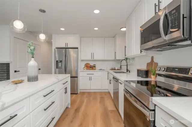 The kitchen is a chef's dream with crisp white cabinetry and stainless appliances.