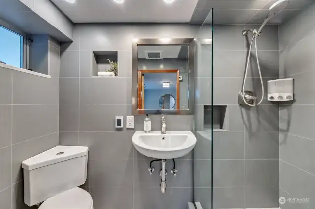 Lower level bathroom boasts sleek updates and radiant flooring in an efficient package