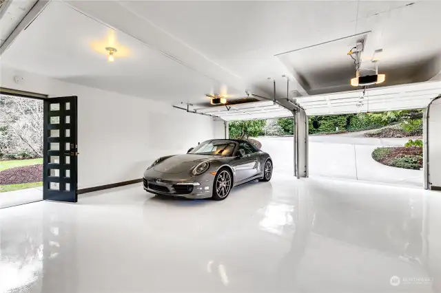 Deep two-car garage with freshly epoxied floor offers plenty of space for additional storage, includes utility sink and belt-drive door openers
