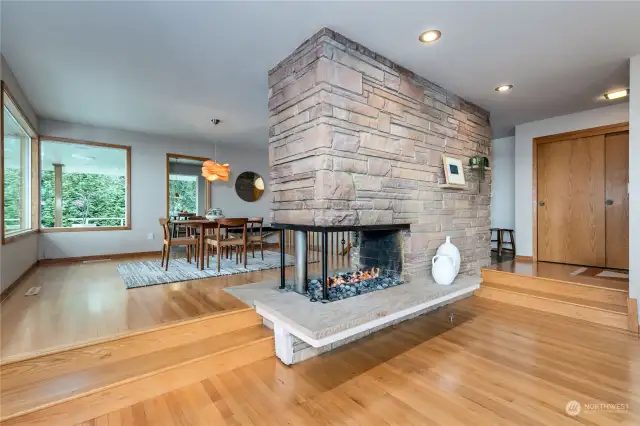 The three-sided gas/wood fireplace anchors the mid-century aesthetic in the common area and offers easy heat for evenings in