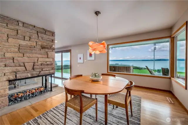 The formal dining room stuns with custom lighting, large picture windows overlooking the water and access to the three-sided gas fireplace for cozy warmth year round