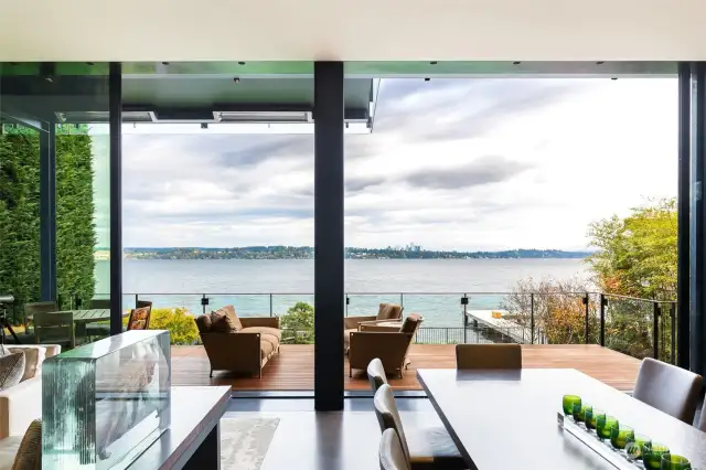 Large scale sliding doors open for full access to outdoor living areas and Lake Washington. Panoramic views of the Cascade mountains, downtown Bellevue skyline and the water.