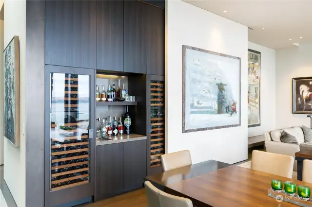 Full hidden bar and climate controlled SubZero wine storage located behind sliding art wall.
