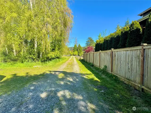 Southern boundary line is the fence. Looking east along current driveway. Looking toward entry on east?
