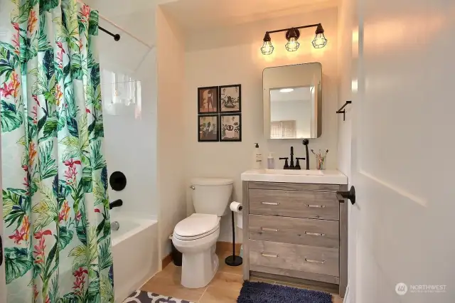 Primary bathroom with tub/shower and small window for natural light.