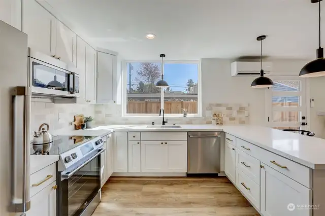 The kitchen showcases white shaker cabinetry, quartz countertops, and stainless steel appliances
