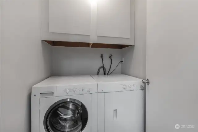 In-unit washer/dryer laundry room with additional storage.