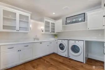 Main laundry room with extra storage, sink and folding counter.  Large pantry is just off picture on the right.
