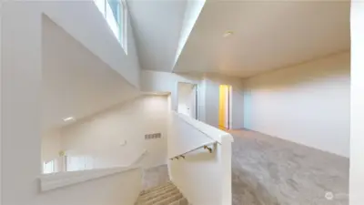 View from the top of the stairs.  The loft is on the right and is flooded with natural light from the window above.