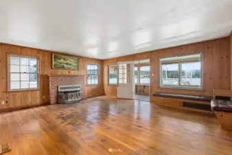 The living area has oak hardwood floors and a lovely gas fireplace with a brick surround. This room opens onto the enclosed sunroom (needing to be finished).