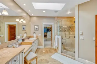 Elegant Primary bathroom with double vanity, large walk-in shower with built-in seat and multi-spray heads.