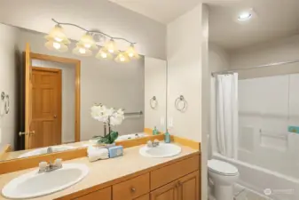 Renovated upstairs hall bathroom features new flooring, toilet, and light fixture (2024)