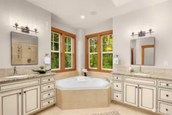 Dual sink vanities and a skylight add to the appeal of the primary bathroom.