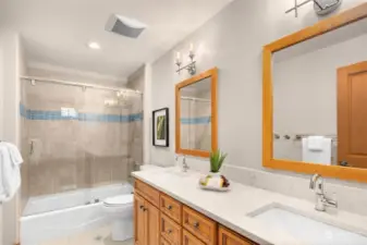 Full bath with dual sink vanity and tub/shower combo.