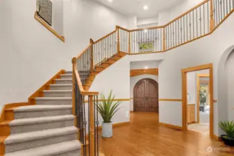A dramatic sweeping staircase leads to the upper level.