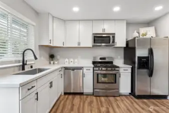 Updated kitchen includes all new cabinets, countertops, sink, faucets, lighting and more!