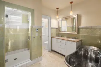 Primary bath has copper soaking tub, vanity with double sinks, tile shower and heated floors.