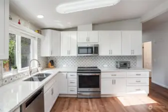A sophisticated range/oven does EVERYTHING, including air frying! The no-edge sink allows for easy kitchen cleanup. GE microwave, Kitchenaid dishwasher, GE refrigerator, GE range/oven all stay with the home.
