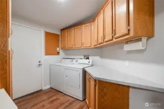 The utility room has plenty of counter space and lots of cabinetry for storage. The washer and dryer remain with the home.