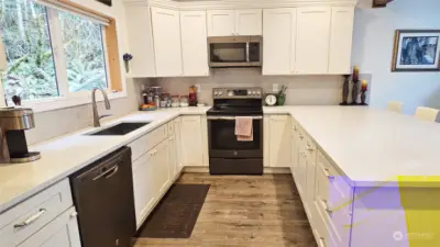 Kitchen appliances stay, including the stack LG washer & dryer in laundry room