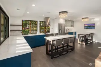 Lower level kitchen with 2 large islands for entertaining, Restoration Hardware hand-blown glass chandeliers, tile hardwood floors and lots of light.