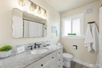 Updated bathroom includes a vanity with ample storage, sturdy fixtures, and stylish lighting.