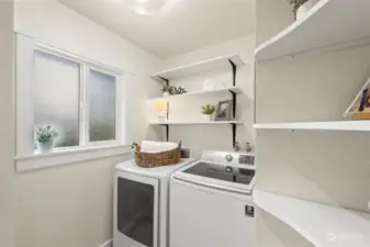 Beautifully updated laundry room has a sliding farmhouse door and includes your new washer and dryer as well as some pantry storage.