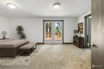 *This photo has been virtually staged* Primary Suite features french doors to back deck, walk-in closet and attached bathroom. Brand new carpet.