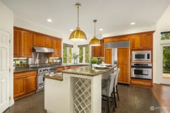 Kitchen appliances include; Subzero refrigerator with custom panels, Viking gas oven with 6-burners, a second GE wall oven, a stainless-steel oven vent hood with 2 warming lights, GE microwave, and stainless steel sink with a pull out faucet.