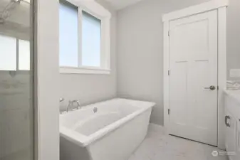 Here, catch a glimpse of the large custom-tiled shower and oversized soaking tub.