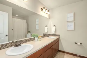 Large hall bath with dual sinks and tub/shower combo.