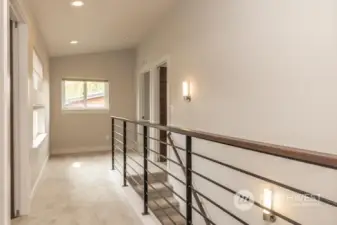 Nice hallway with a beautiful railing and lots of windows.