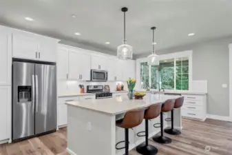 Welcome to the sleek white kitchen with large island and plenty of storage to go around.