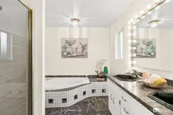 The ensuite bath off of the primary bedroom has marble floors and countertops.  Double sinks and large soaker tub.