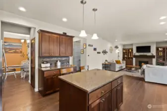 Large kitchen with tons of rich, upgraded cabinetry opens to living and dining