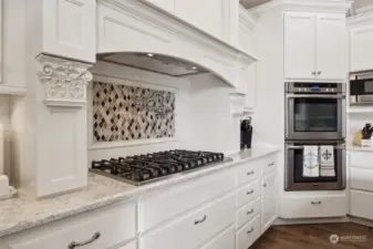 6 burner gas cooktop, double oven, pot filler, stunning white cabinets with pull outs & soft close doors/drawers, the corbals next to the cooktop pull out for the ultimate built in spice racks- what's not to love in this dream kitchen!