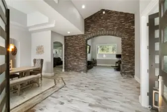 Another view as you enter the foyer and experience the grand stone wall. The space beyond the wall is currently a game room but could be a formal living room or?