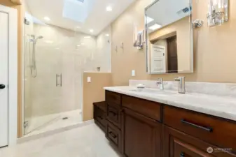 2nd floor guest bathroom with Italian marble and custom cabinets. Bench in shower and skylight.