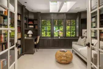 The second floor library with floor to ceiling bookshelves and built-in desk. French doors allow natural light to fill the room, while simultaneously creating privacy.