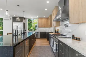 Truly a gorgeous kitchen with all the custom touches, full slab backsplash, beverage fridge and wine fridge, tons of cabinets and open to the living and dining area.