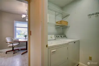 Laundry room equipped with floor-to-ceiling storage shelving discreetly positioned behind the door. Additionally, houses the water heater.