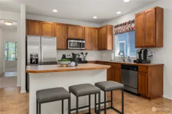 Experience the elegance of the kitchen, where stunning oak cabinets, a center eat-in island, stainless steel appliances, and ample counter space come together to create a functional and inviting culinary space.