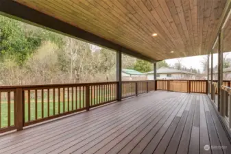 Oversized lighted deck with gate that leads to a fenced side yard perfect for a puppy dog area!