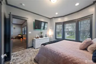 Enjoy the convenience of a main floor bedroom with a luxurious en suite bathroom, enhanced by beautiful windows that fill the space with natural light and elegant crown molding that adds a touch of sophistication.