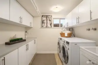 Large laundry room with utility tub, lots of storage, and room for an extra refrigerator.